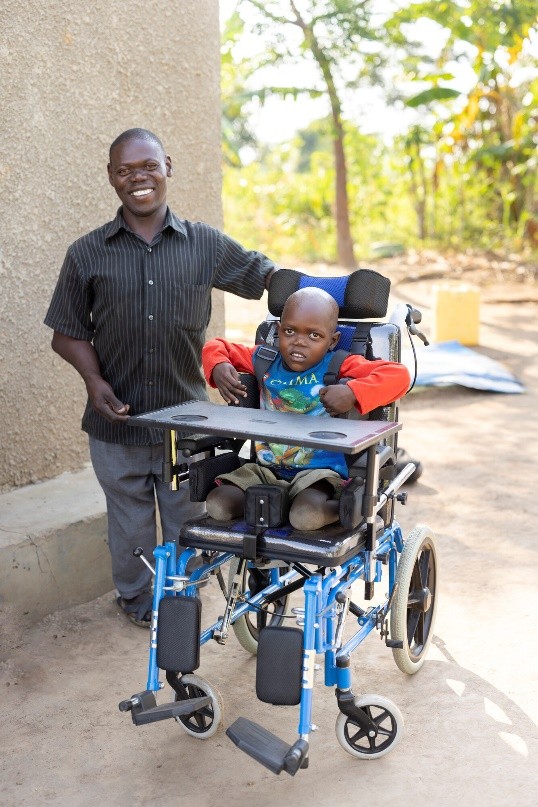 Wheelchair Six-year-old Robert and his dad celebrate the gift of a wheelchair they received from ChildFund’s local partner, Partners for Children Worldwide.