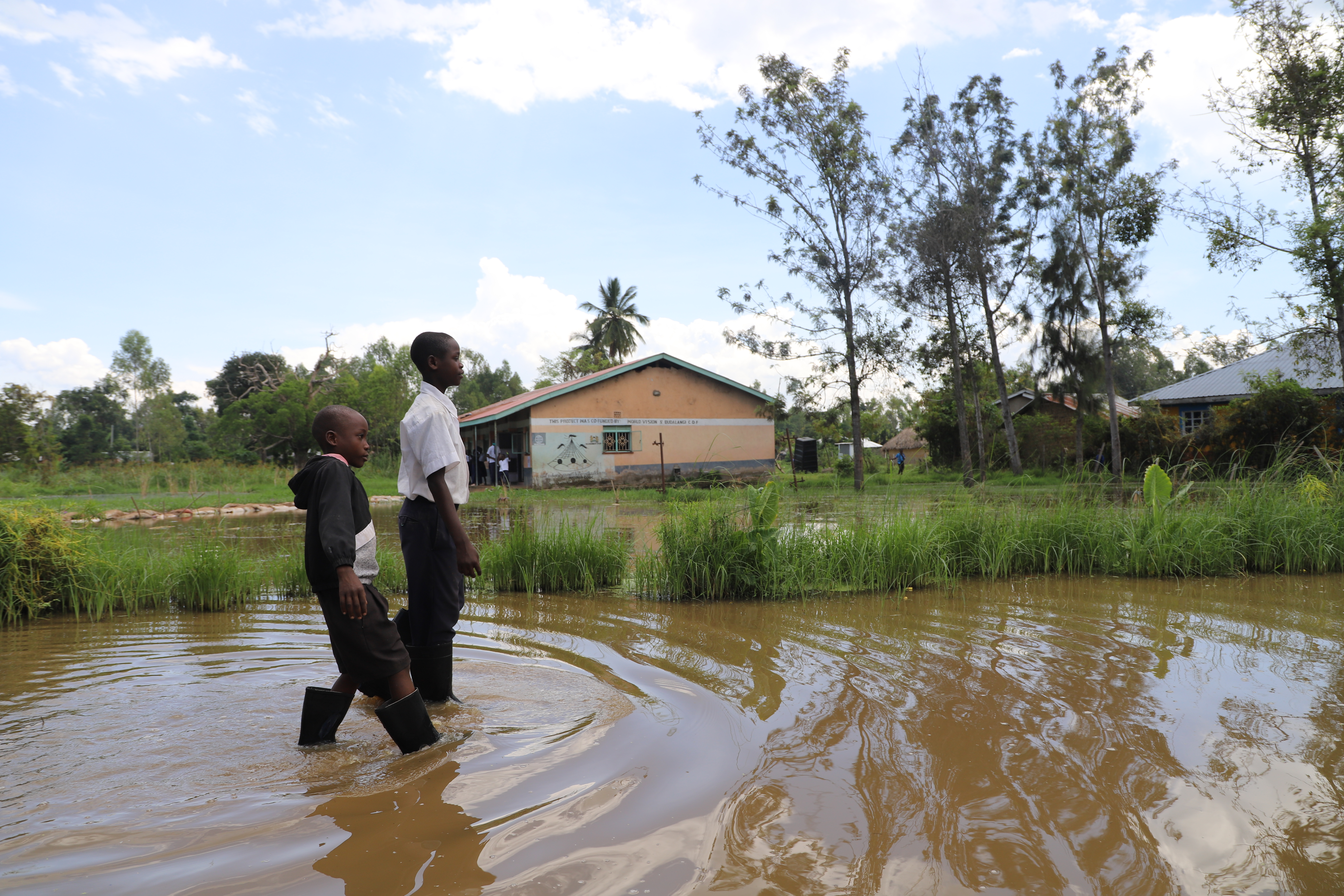 A boy wades through high water in rural Kenya.